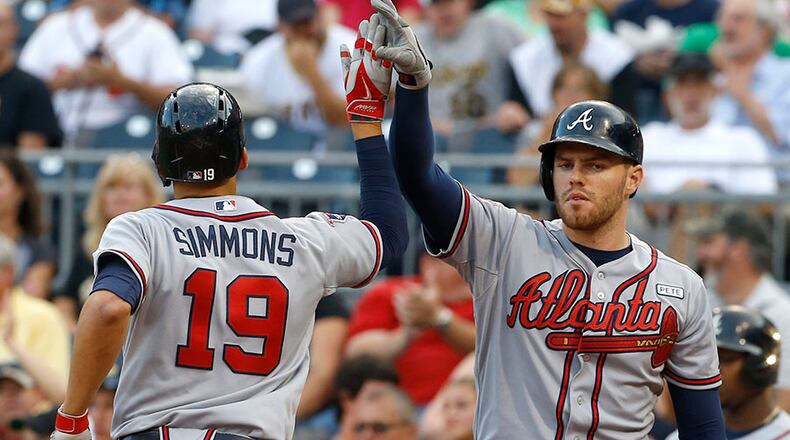 Atlanta Braves' Andrelton Simmons is greeted by on-deck batter Freddie Freeman after hitting a solo home run in the first inning of the Braves' 7-3 in over the Pirates Monday, Aug. 18, 2014, in Pittsburgh.