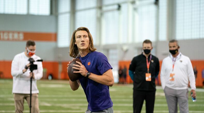 Former Clemson quarterback Trevor Lawrence warming up under the watchful eye of Jacksonville coach Urban Meyer in the background.  (Photo courtesy of David Platt/Clemson Athletics)