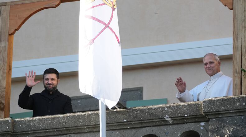 Ukraine's President Volodymyr Zelenskyy and Pope Leo XIV wave to journalists during their meeting in Castel Gandolfo, Italy, Tuesday, Dec. 9, 2025. (AP Photo/Andrew Medichini)