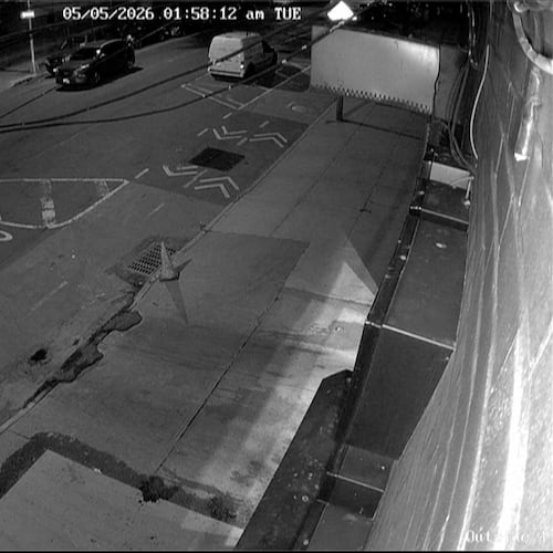 In this image from a surveillance video provided by AKI AUTO CARE, one of three people descends into a sewer on a street in New York, on May 5, 2026. (AKI AUTO CARE via AP)