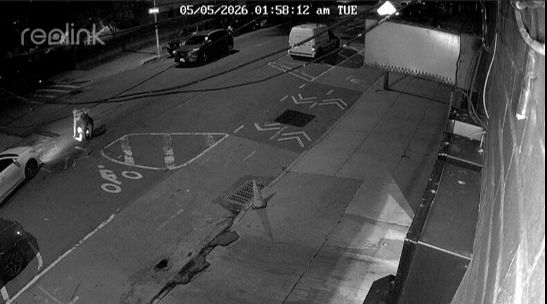 In this image from a surveillance video provided by AKI AUTO CARE, one of three people descends into a sewer on a street in New York, on May 5, 2026. (AKI AUTO CARE via AP)