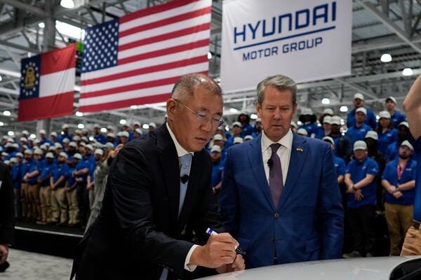 Euisun Chung (left), executive chair of Hyundai Motor Company, stands with Georgia Gov. Brian Kemp as Chung signs an IONIQ 9 EV vehicle during a media tour and grand opening at the Hyundai Motor Group Metaplant America, March 26, 2025, in Ellabell, Ga. (Mike Stewart/AP)