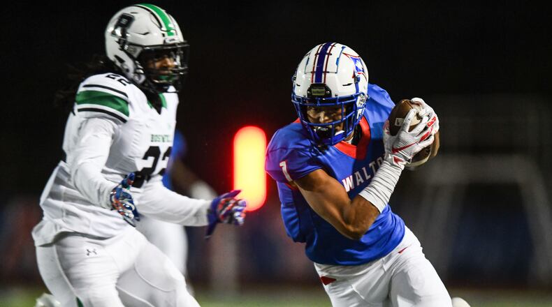 Walton's Dominick Blaylock (1) catches a pass ahead of Roswell's Tyron Hopper (22) Friday, Oct. 19, 2018, in Marietta.