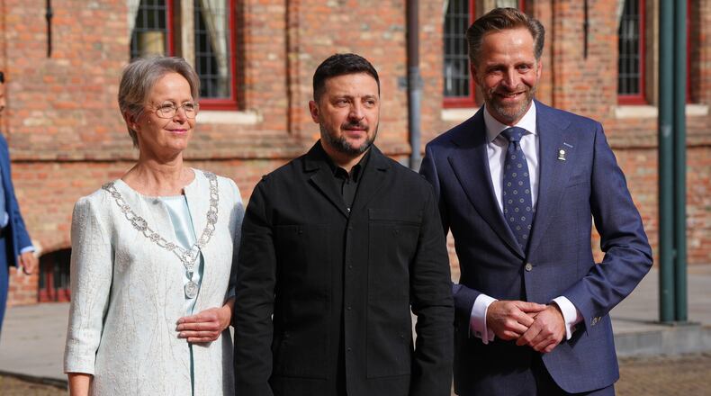 The The King's Commissioner of Zeeland Hugo de Jonge, right, and the Mayor of Middleburg Yvonne van Mastrigt, left, welcome Ukraine's President Volodymyr Zelenskyy for the International Four Freedoms Award ceremony in Middelburg, Netherlands, Thursday, April 16, 2026. (AP Photo/Peter Dejong)