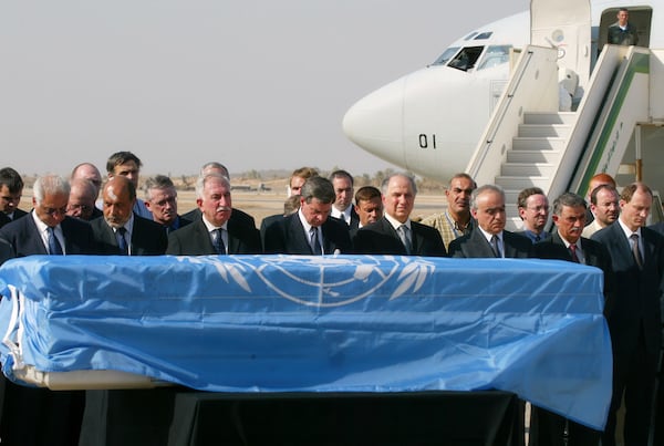 FILE - U.S. administrator in Iraq Paul Bremer, fourth left, along with UN and Iraqi officials pays last respects before Sergio Vieira de Mello's coffin, draped in a UN flag is loaded on a Brazilian presidential plane at Baghdad international airport, in Baghdad, Iraq, Aug. 22, 2003. Vieira de Mello, the top U.N. official in Iraq, was killed in a suicide truck bombing attack on U.N. headquarters that killed at least 22 other people and left more than 100 injured. (AP Photo/Manish Swarup, File)