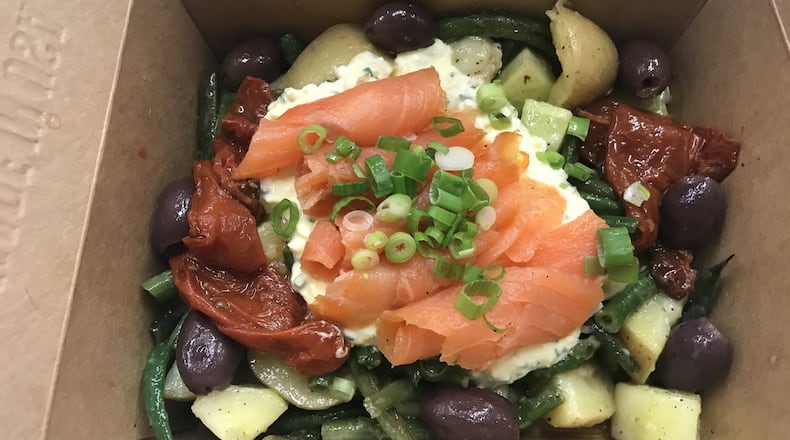 The star of the Ole Reliable lunch menu is the smoked salmon salad niçoise, a feel-good mélange of potatoes, green beans, kalamata olives, preserved tomatoes and cucumber, with a layer of egg salad and smoked salmon rolls garnished with scallions. LIGAYA FIGUERAS / LFIGUERAS@AJC.COM.