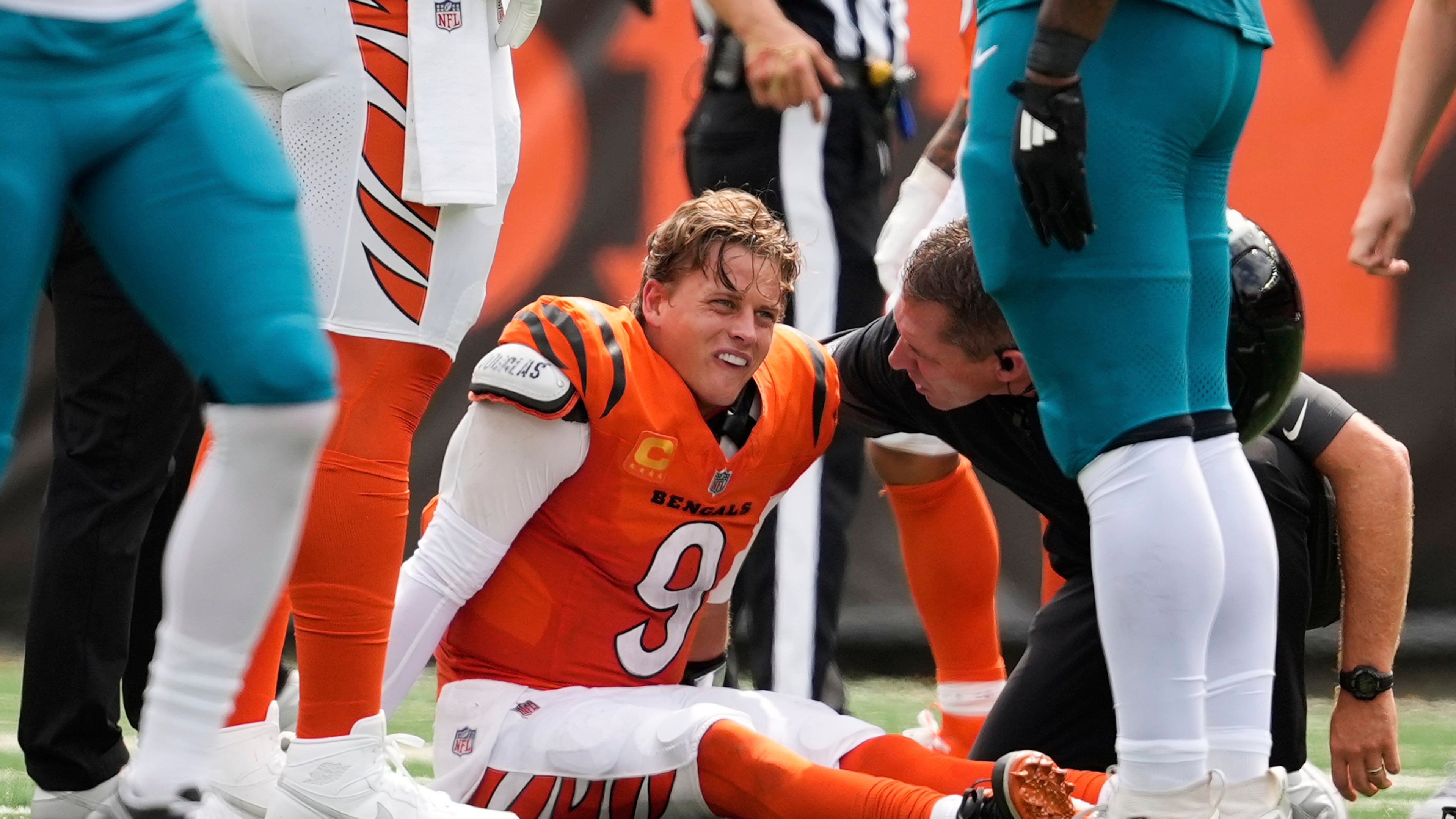 Cincinnati Bengals quarterback Joe Burrow (9) grimaces aft being sacked by Jacksonville Jaguars defensive tackle Arik Armstead (91) during the first half of an NFL football game, Sunday, Sept. 14, 2025, in Cincinnati. (AP Photo/Carolyn Kaster)