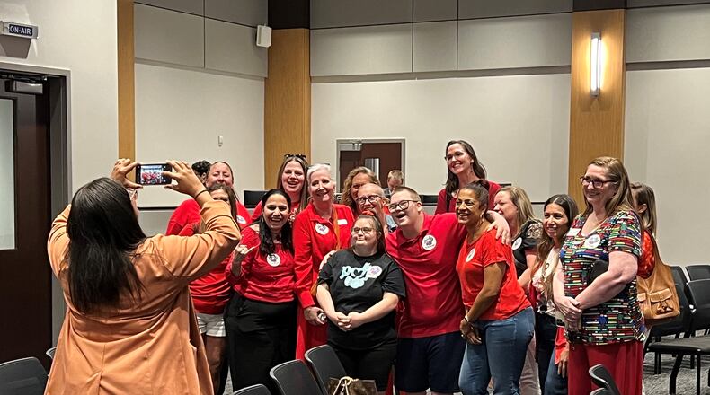 Ashlynn Rich (center) poses for a photo with supporters after the Cobb County school board meeting on Thursday, June 13, 2024. Rich, who has Down syndrome, recently graduated from Sprayberry High School, but was excluded from the main ceremony. Cobb Superintendent Chris Ragsdale apologized at Thursday's meeting. (Cassidy Alexander/AJC)