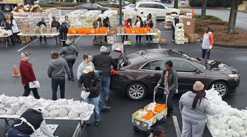 Folks from the Atlanta Community Food Bank and Antioch Baptist Church pass out groceries in Atlanta earlier this year. Bob Andres / bandres@ajc.com