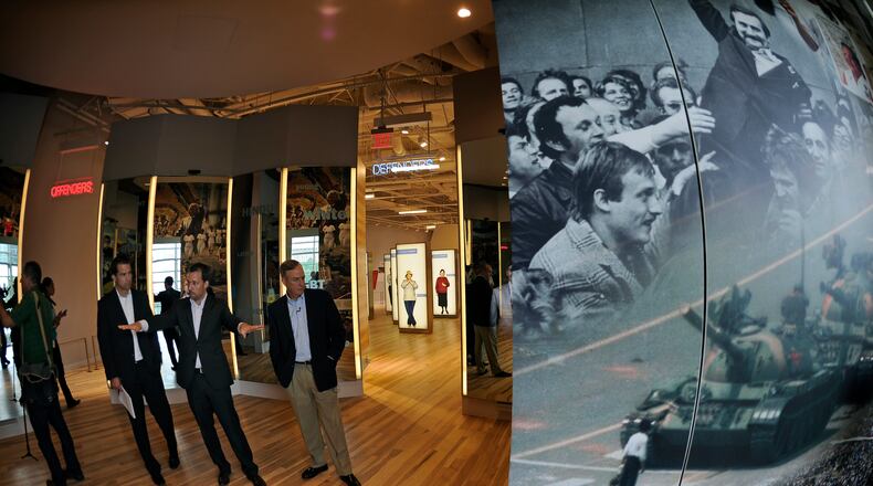 National Center for Civil and Human Rights CEO Doug Shipman, center, explains exhibits on the third floor, including Poland's Lech Walesa, top right, and Tiananmen Square's anonymous "tank man" bottom, Tuesday, June 10, 2014, in Atlanta. The main exhibits include: the King papers on the first floor, the second floor main entrance, open space and mural, the lunch counter, interactive TV displays, Freedom Rider Bus, and stained glass portraits of four girls killed during violence in Alabama, and the third floor showcases the global human rights footprint with intimate cone-shaped movie theaters and a villains and champions exhibit. David Tulis / AJC Special