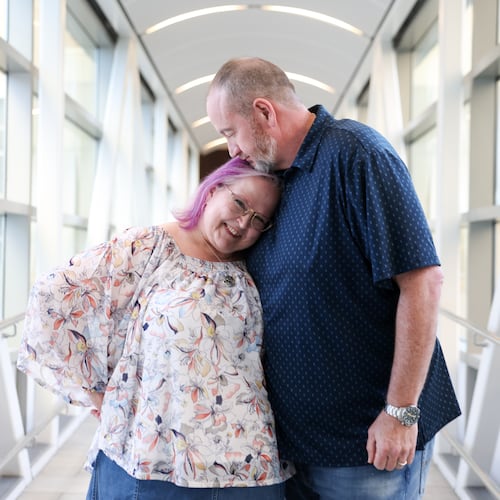Tyra and Shane Burton pose on the sky bridge from the Hyatt Regency in Atlanta on Aug. 19, 2026. The couple met at Dragon Con at the Hyatt Regency in 2009. (Arvin Temkar/AJC)