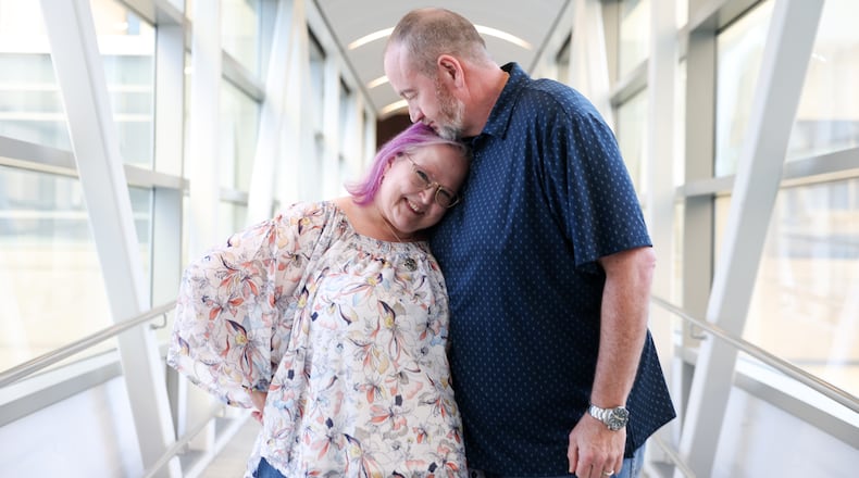 Tyra and Shane Burton pose on the sky bridge from the Hyatt Regency in Atlanta on Aug. 19, 2026. The couple met at Dragon Con at the Hyatt Regency in 2009. (Arvin Temkar/AJC)
