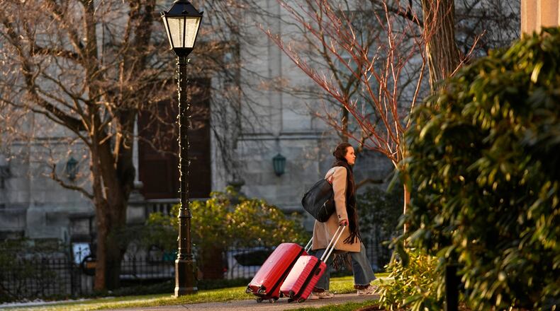 A Brown University student leaves campus, Tuesday, Dec. 16, 2025, after all classes, exams and papers were canceled for the rest of the Fall 2025 semester following the school shooting, in Providence, R.I. (AP Photo/Robert F. Bukaty)