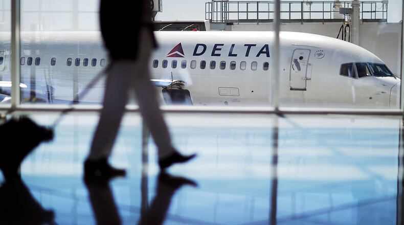 In this Oct. 13, 2016 file photo, a Delta Air Lines jet sits at a gate at Hartsfield-Jackson Atlanta International Airport in Atlanta. Delta Air Lines says it has canceled more than 3,000 flights this week as it continues to struggle in the aftermath of a storm that hit its hub airport in Atlanta.