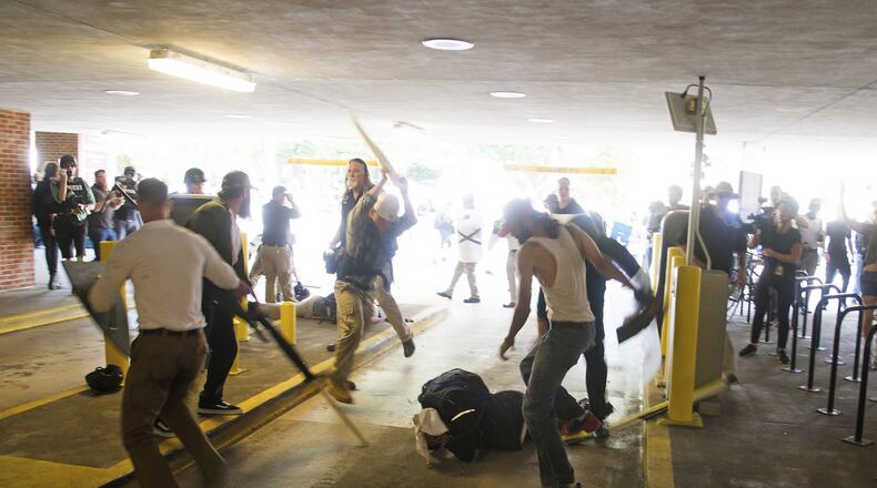 In this Saturday, Aug. 12, 2017 photo, DeAndre Harris, bottom is assaulted in a parking garage beside the Charlottesville police station after a white nationalist rally was disbursed by police. ZACH D. ROBERTS VIA AP