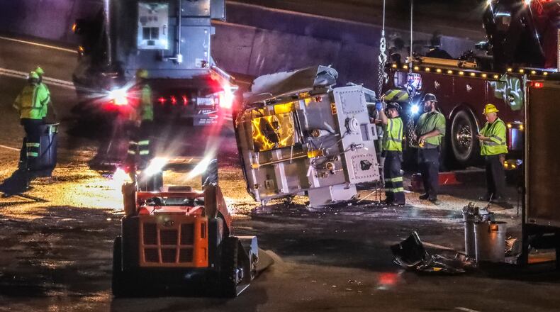 The Georgia Department of Transportation is conducting emergency repairs after a tractor-trailer overturned Tuesday morning at Spaghetti Junction. (John Spink/AJC)