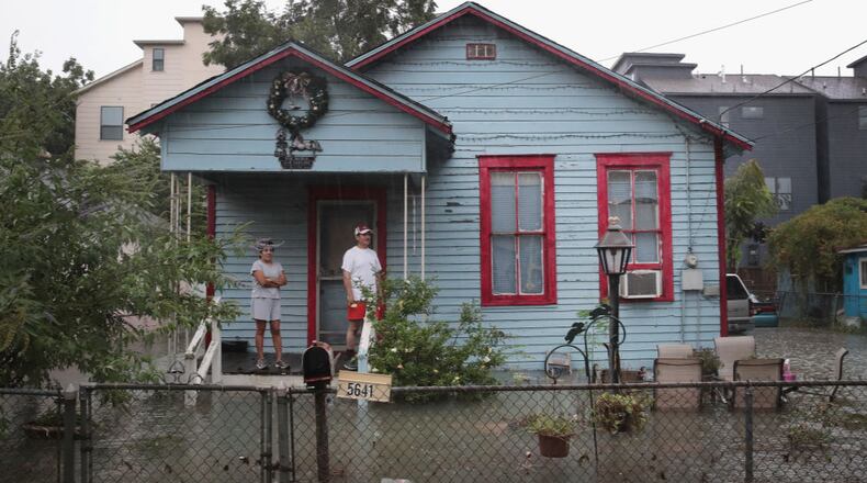 HOUSTON, TX - AUGUST 27: People on a porch watch as rain from Hurricane Harvey inundates the Cottage Grove neighborhood on August 27, 2017 in Houston, Texas. Harvey, which made landfall north of Corpus Christi late Friday evening, is expected to dump upwards to 40 inches of rain in Texas over the next couple of days. (Photo by Scott Olson/Getty Images)