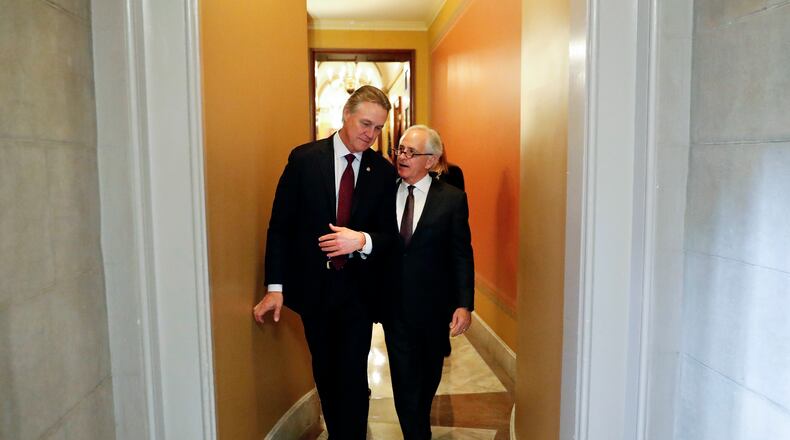 Sen. David Perdue, R-Ga., left, and Sen. Bob Corker, R-Tenn., walk down the hallway after attending a closed-door meeting with fellow Republican senators on Jan. 22, 2018 on Capitol Hill. (AP Photo/Pablo Martinez Monsivais)