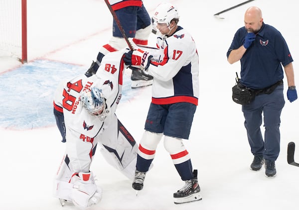 Washington Capitals goaltender Logan Thompson (48) stumbles as he is helped off the ice by teammate Dylan Strome (17) during the third period of Game 3 of a first-round NHL hockey playoff series against the Montreal Canadiens in Montreal, Friday, April 25, 2025. (Christinne Muschi/The Canadian Press via AP