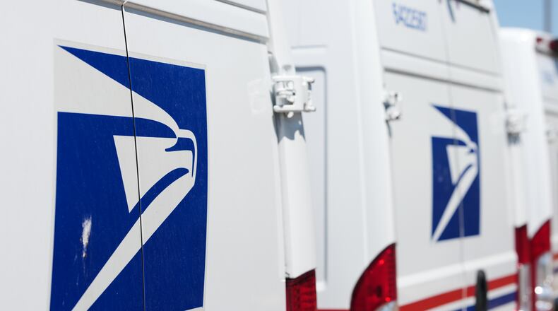 Delivery vans bearing the logo sit during a protest staged as part of a countrywide National Day of Action Tuesday, July 28, 2026, outside the main United States Postal Service headquarters in northeast Denver. (AP Photo/David Zalubowski)