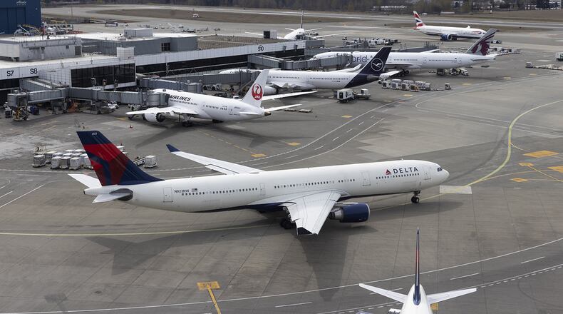 A Delta jet pulls out from the A concourse at SEA and passes by the International Arrivals Facilities gates, the S concourse, on its way to the runway, Wednesday, April 5, 2023. (Ellen M. Banner/Seattle Times/TNS)