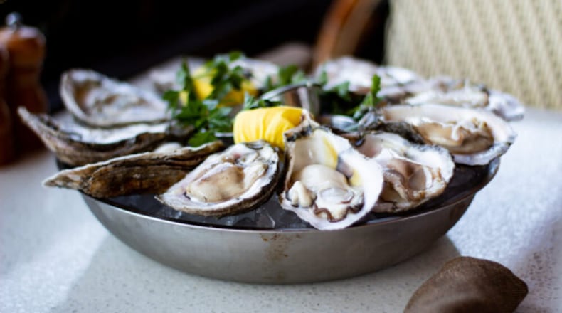 A plate of fresh, raw oysters with lemon and parsley sits on a table at C&S Seafood & Oyster Bar. (Courtesy of Sarah Swetlik/Fresh Take Georgia)