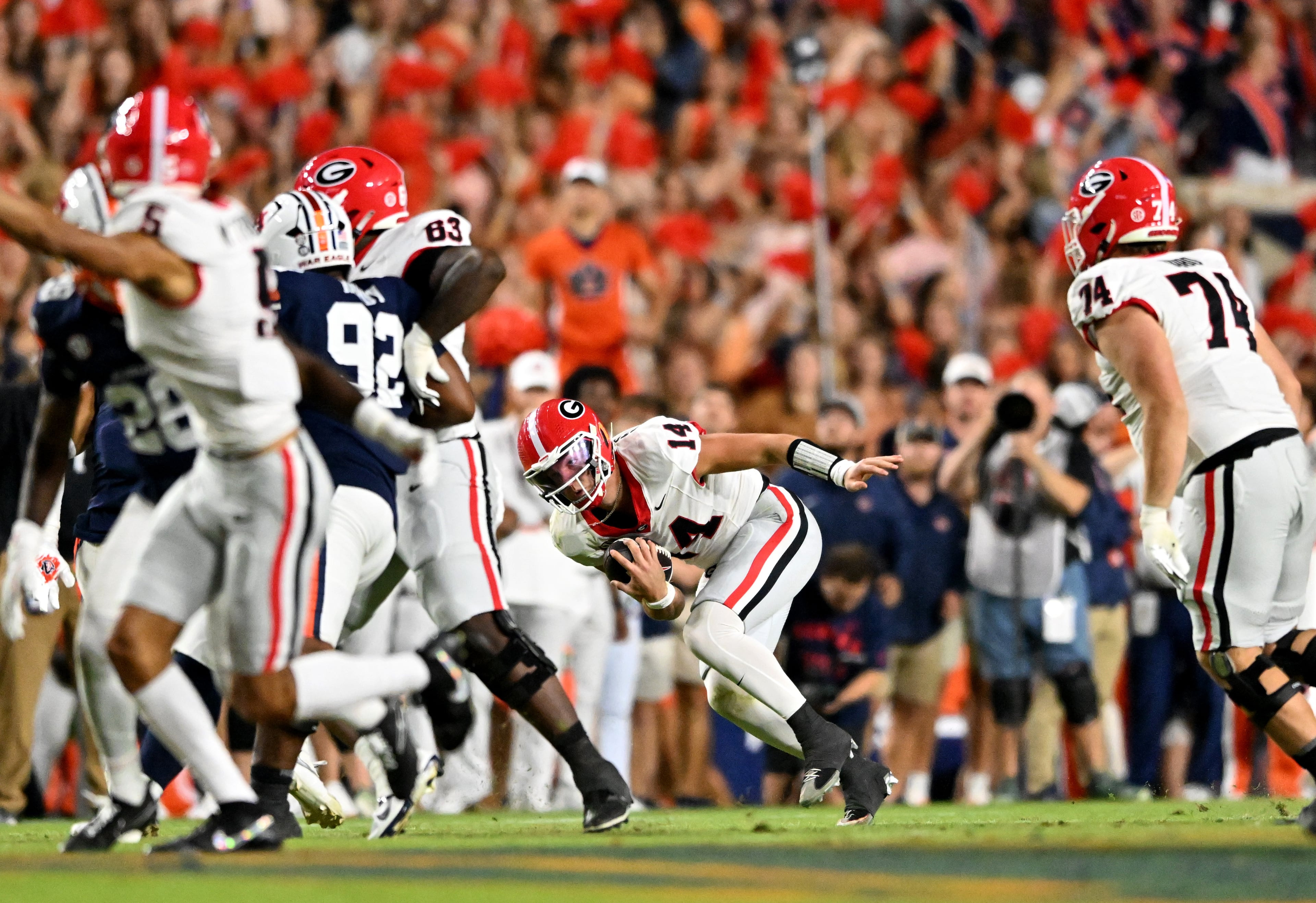 Georgia quarterback Gunner Stockton (14) struggles to maintain balance during the first half in a NCAA college football game at Jordan-Hare Stadium, Saturday, October 11, 2025, in Auburn, Ala. (Hyosub Shin / AJC)