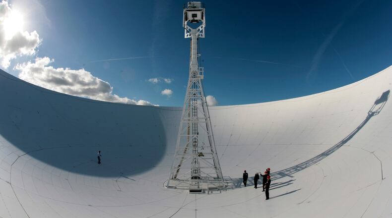 FILE - Members of a conference to mark the 50th anniversary of space travel stand in the dish of the The Lovell Telescope at Jodrell Bank Observatory, Macclesfield, England Thursday Oct. 4, 2007. (AP Photo/Jon Super, file)
