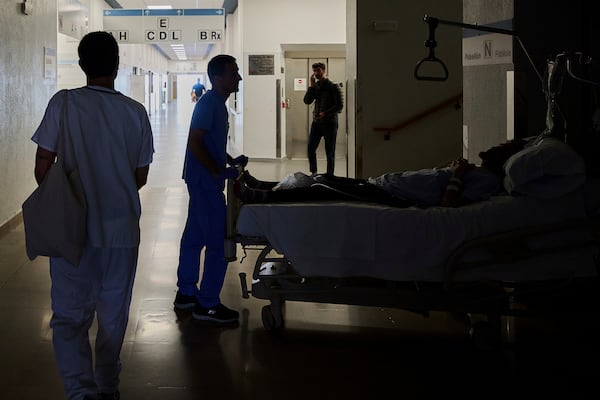 A medical staffer relocates a patient during a nationwide power outage in Pamplona, northern Spain, Monday, April 28, 2025. (AP Photo/Miguel Oses)