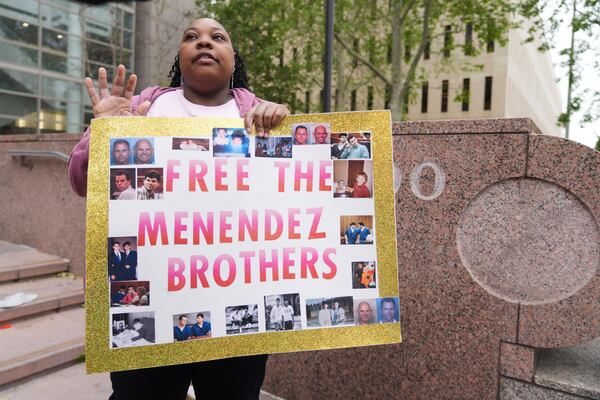 A supporter holds a sign outside of court before a hearing in the case of Erik and Lyle Menendez Thursday, April 17, 2025, in Los Angeles. (AP Photo/Damian Dovarganes)