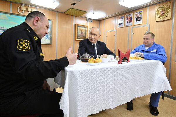 Russian President Vladimir Putin, center, accompanied by Russian Navy Commander-in-Chief Admiral Alexander Moiseyev, left, speaks with crew members of the nuclear-powered submarine Arkhangelsk at the Atomflot, a service base for nuclear-powered fleet, in Murmansk, Russia, Thursday, March 27, 2025. (Kirill Zykov, Sputnik, Kremlin Pool Photo via AP)