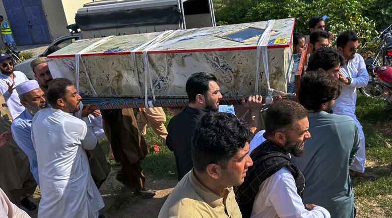 In this photo taken with a smartphone, mourners carry the casket of a victim who was killed in Friday's suicide bombing at a mosque, for a funeral in Kohat, in northwestern Pakistan, Saturday, Sept. 19, 2026. (AP Photo/Maaz Awan)