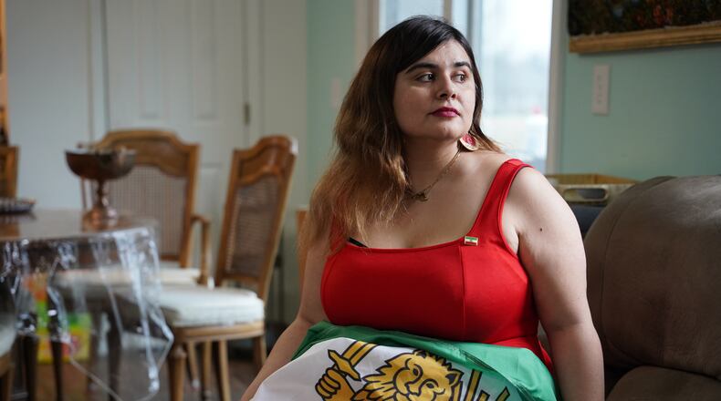 Ava Farhadi, a 33-year-old postdoctoral researcher from Iran, poses for a portrait with an Iranian flag in her home in Lafayette, Ind., Tuesday, March 3, 2026. (AP Photo/Obed Lamy)