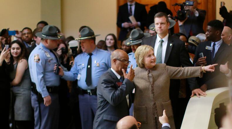 Hillary Clinton is escorted by state Rep. Calvin Smyre, D - Columbus, on Friday as she departed the Capitol. Bob Andres, bandres@ajc.com