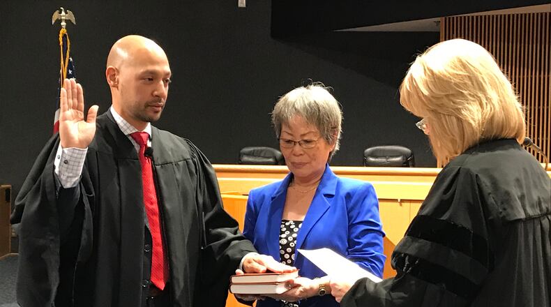Ramon Alvarado (left) is sworn in as a Gwinnett County Recorder's Court judge by State Court Judge Emily Brantley (right) as his mother, YuSun Alvarado, looks on. Alvarado was the first Hispanic judge in Gwinnett County's history. He died this week. TYLER ESTEP / TYLER.ESTEP@AJC.COM AJC FILE PHOTO