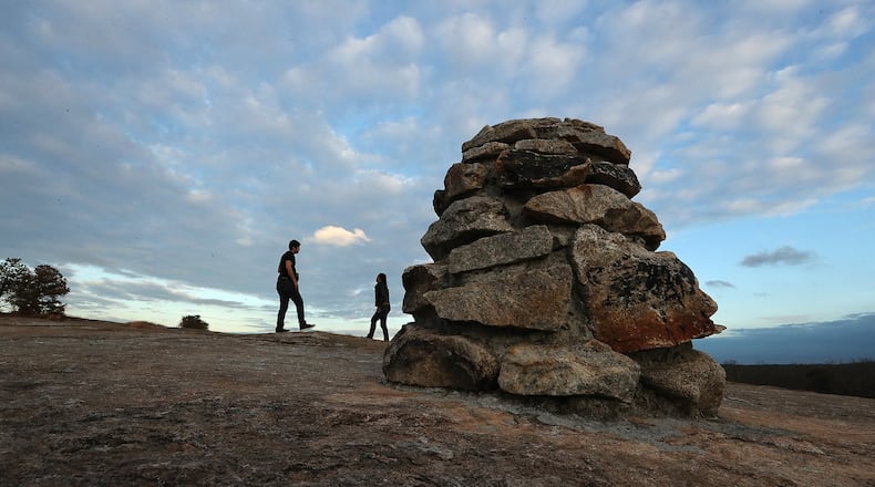 Preston Hamilton and Rose Gerazine of Atlanta follow stone markers exploring a section of the Arabia Mountain Trail southeast of Atlanta near Lithonia. The PATH Trails network meanders through rock outcroppings, colorful wildflower fields, rushing streams, and towering pines from the Mall at Stonecrest into Panola Mountain State Park and beyond featuring 7,000 acres of green space and Arabia Mountain. CURTIS COMPTON / CCOMPTON@AJC.COM