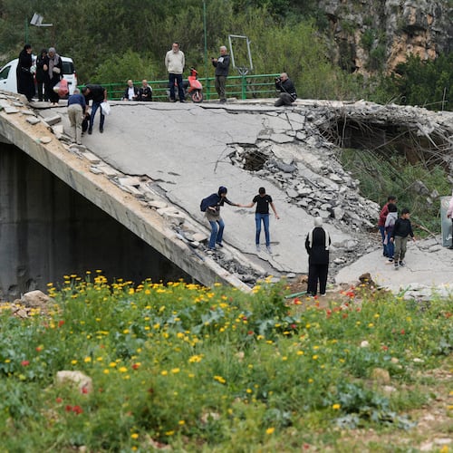 Displaced people cross on foot over a destroyed bridge as they return to their villages following a ceasefire between Hezbollah and Israel, in Tayr Felsay village near the city of Tyre, southern Lebanon, Sunday, April 19, 2026. (AP Photo/Bilal Hussein)