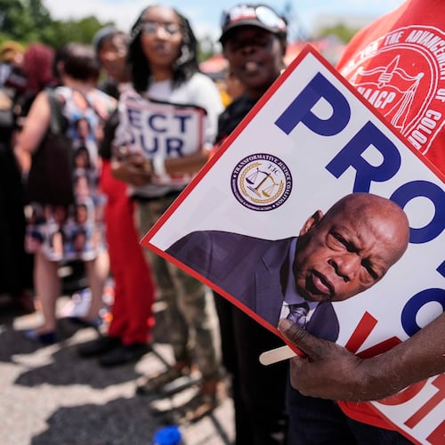 A protestor holds a sign of the late Georgia Congressman John Lewis during a voting rally, Saturday, May 16, 2026, in Montgomery, Ala. (Mike Stewart/AP)