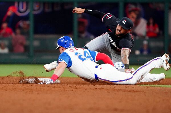 Atlanta Braves' Jarred Kelenic (24) dives into second base against Minnesota Twins shortstop Carlos Correa, right, during the sixth inning of a baseball game Saturday, April 19, 2025, in Atlanta. After a review, Correa was ruled out on the play. (AP Photo/John David Mercer)
