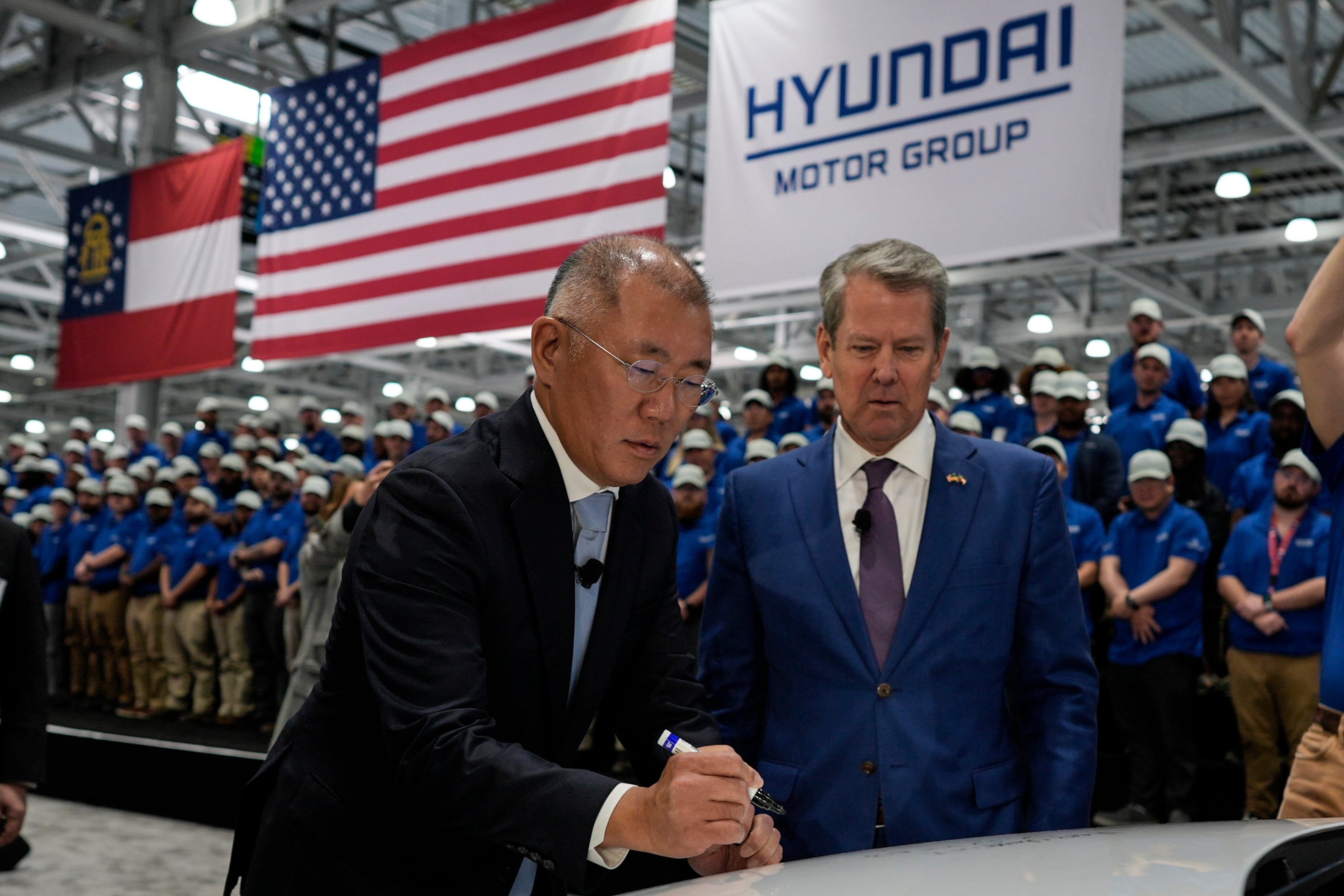 Hyundai’s chairman, Euisun Chung (left), stands with Georgia Gov. Brian Kemp as Chung signs an IONIQ 9 EV vehicle during a media tour and grand opening at the Hyundai Motor Group Metaplant America on March 26, 2025, in Ellabell, Ga. (Mike Stewart/AP)