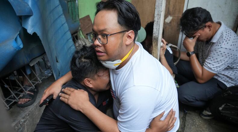 A man cries at the site of a fire in Jakarta, Indonesia, Tuesday, Dec. 9, 2025. (AP Photo/Dita Alangkara)