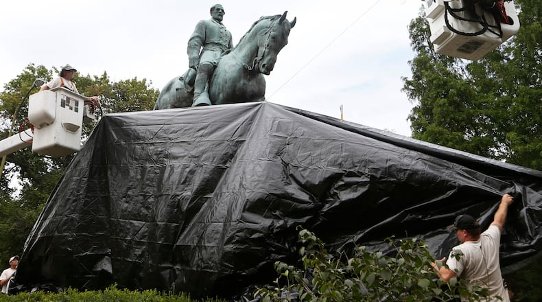 City workers drape a tarp over the statue of Confederate Gen. Robert E. Lee in Emancipation Park in Charlottesville, Va. AP file/Steve Helber