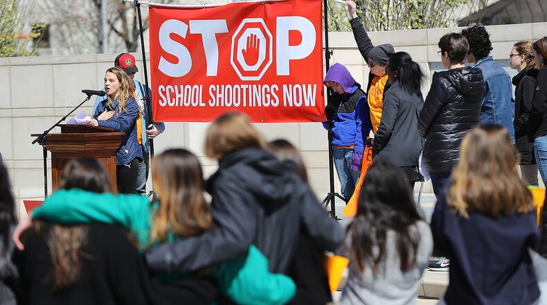 Students look on while Druid Hills High School junior Anabette Vellines speaks out against gun violence during a rally in Liberty Plaza at the Georgia Capitol after their school walkouts Wednesday. At the conclusion of the rally, many attempted to meet with their state representatives.  Curtis Compton/ccompton@ajc.com