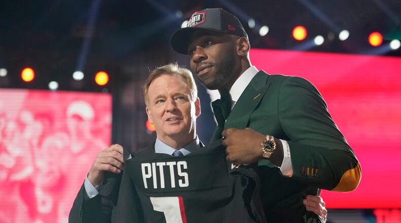 Florida tight end Kyle Pitts, right, holds a jersey with NFL Commissioner Roger Goodell after he was chosen by the Atlanta Falcons with the fourth pick in the NFL football draft, Thursday, April 29, 2021, in Cleveland. (AP Photo/Tony Dejak)