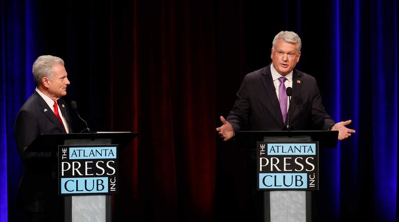 U.S. Rep. Mike Collins, R-Jackson, responds to a question from U.S. Rep. Buddy Carter, R-St. Simons Island, during the Atlanta Press Club's Republican Loudermilk-Young debate at Georgia Public Broadcasting in Midtown, Atlanta, on Sunday, April 26, 2026. (Miguel Martinez/Atlanta Journal-Constitution via AP)