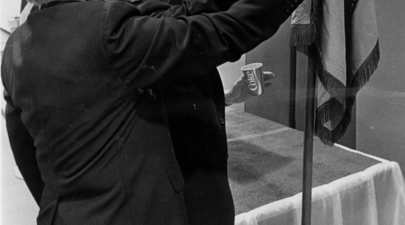 This is a 1984 photo of the Second Annual Boys High School Alumni Association reunion. Albert Jones (left), Class of 1934 and Bernie Abrams, Class of 1943, look at ROTC flag and anniversary banners. (AJC FILE PHOTO)