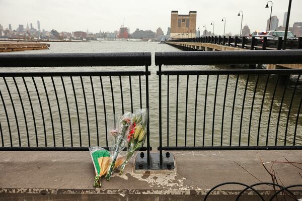 Flowers rest at the end of a pier, Friday, April 11, 2025, near the site where a sightseeing helicopter crashed a day earlier into the Hudson River in Jersey City, N.J. (AP Photo/Yuki Iwamura)