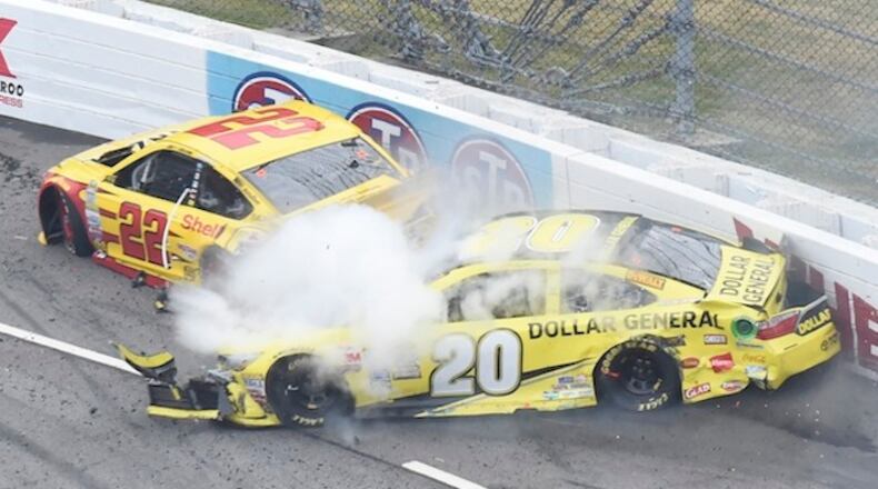 Joey Logano (22) and Matt Kenseth (20) tangle in tun one during the Sprint Cup auto race at the Martinsville Speedway in Martinsville, Va., Sunday, Nov. 1, 2015. (AP Photo/Don Petersen)