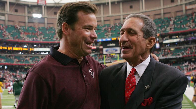 Former Falcons head Coach Jim Mora celebrates with team owner Arthur Blank after a game against the Cardinals at the Georgia Dome on September 26, 2004 in Atlanta. The Falcons defeated the Cardinals 6-3.