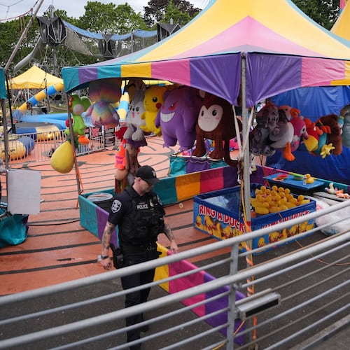 A police officer responds after a shooting at Seattle Center during the Bite of Seattle food festival Sunday, July 26, 2026, in Seattle, Wash. (AP Photo/Lindsey Wasson)